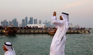 Un ciudadano catarí toma una foto con el anuncio del Mundial al fondo, en la zona de La Corniche de Doha.