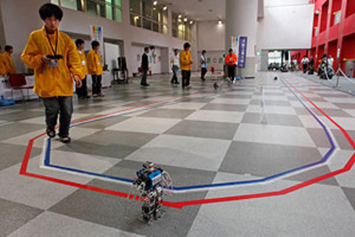 Un estudiante del Instituto de Tecnología de Osaka controla un robot durante la maratón Un estudiante del Instituto de Tecnología de Osaka controla un robot durante la maratón