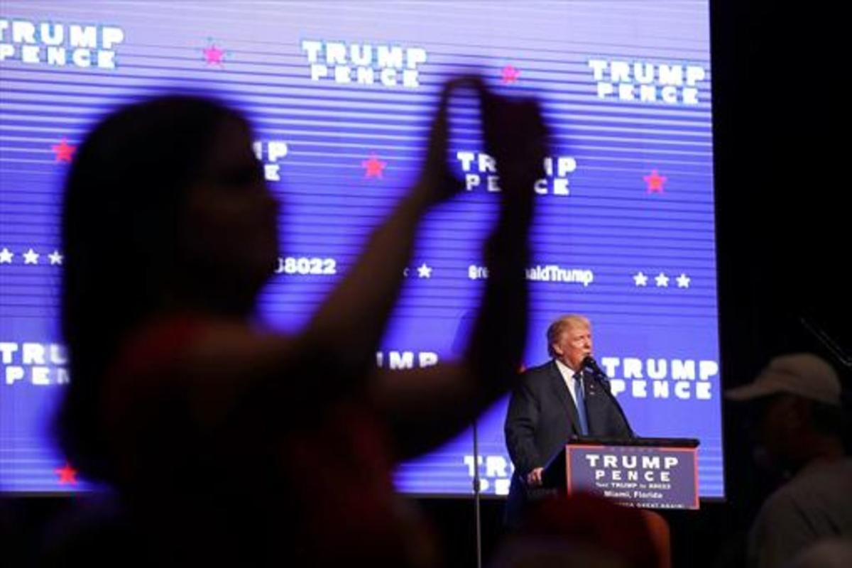 Una electora de Trump se hace una foto para las redes sociales, durante un mitin en Miami. Una electora de Trump se hace una foto para las redes sociales, durante un mitin en Miami.
