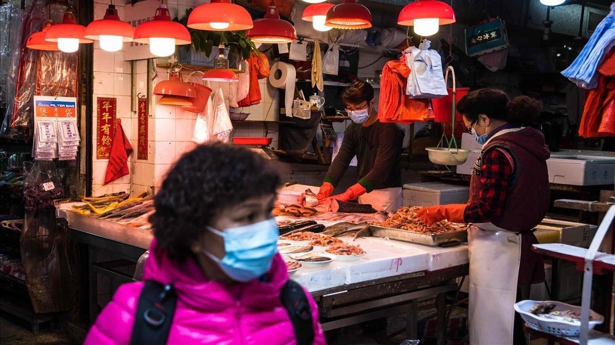 Una mujer con una mascarilla en un mercado de Hong Kong, este miércoles.
