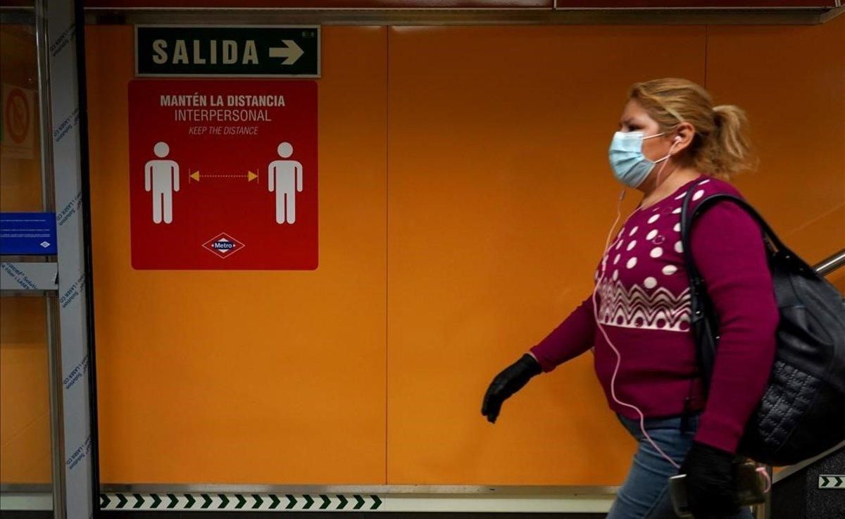 Una mujer en el metro de Madrid, donde pegatinas y carteles advierten de que hay que mantener la distancia interpersonal para evitar el contagio por coronavirus. Una mujer en el metro de Madrid, donde pegatinas y carteles advierten de que hay que mantener la distancia interpersonal para evitar el contagio por coronavirus.