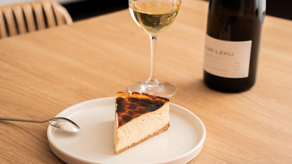 Una porción de tarta de queso y un vino de Jon Cake & Wines.