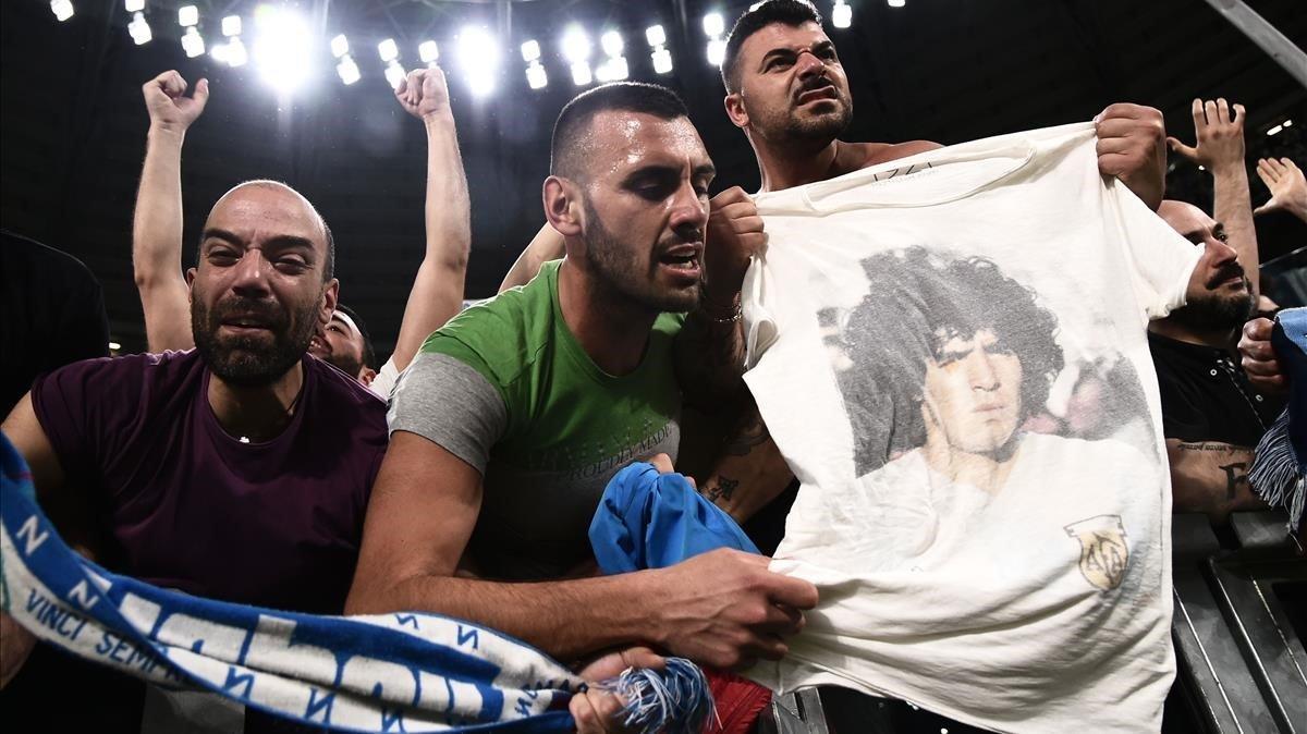 Seguidores del Nápoles celebran el final de un partido con una camiseta y la imagen de Maradona.