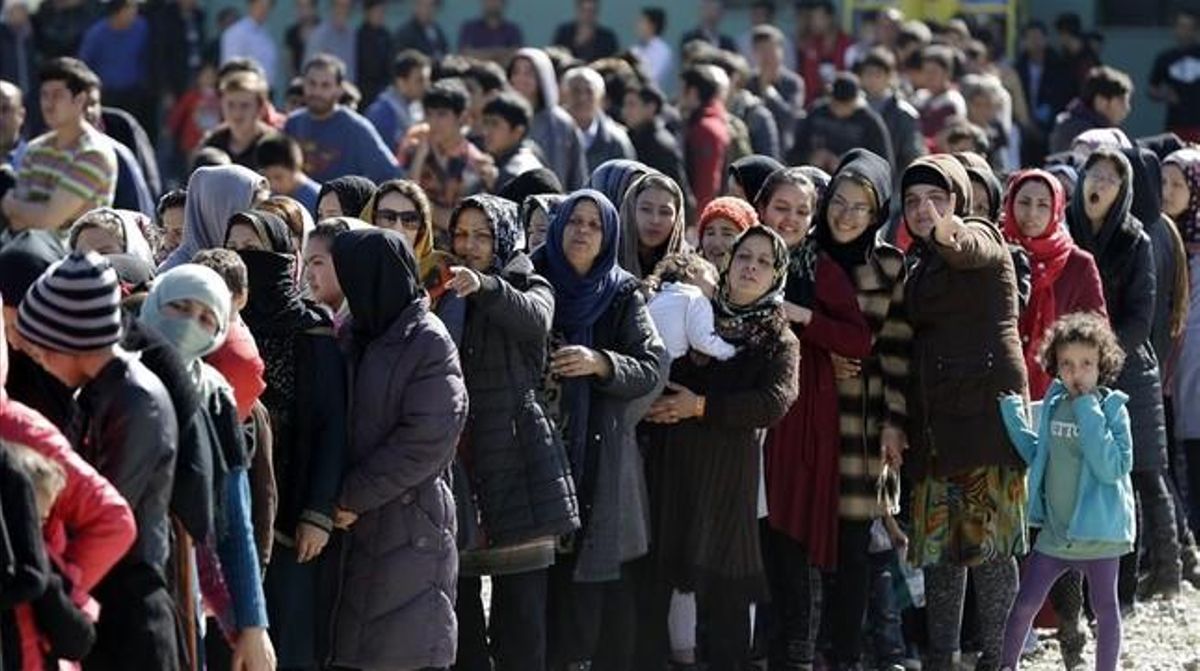 Refugiados afganos reciben comida en Atenas. Refugiados afganos reciben comida en Atenas.