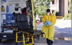 Técnicos sanitarios desinfectan una ambulacia en el Hospital de Igualada.