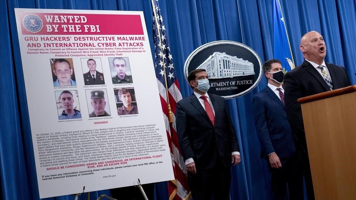 Un cartel muestra las fotografías de los seis ciudadanos rusos, agentes de la inteligencia militar, en busca y camptura por el FBI estadounidense. Un cartel muestra las fotografías de los seis ciudadanos rusos, agentes de la inteligencia militar, en busca y camptura por el FBI estadounidense.