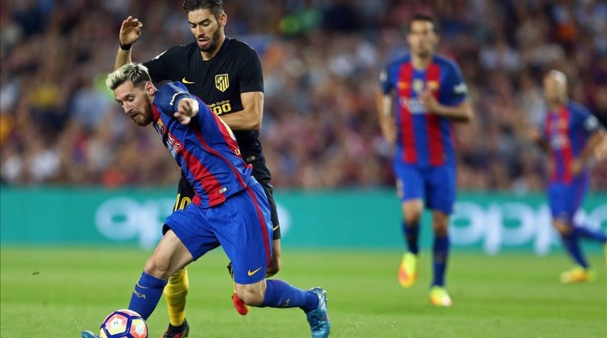 Messi disputa un balón con Carrasco en el Camp Nou antes de lesionarse.