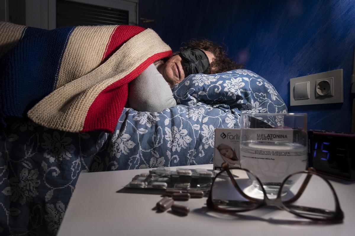 Una mujer duerme con ojeras junto a comprimidos de melatonina que ayudan a conciliar el sueño