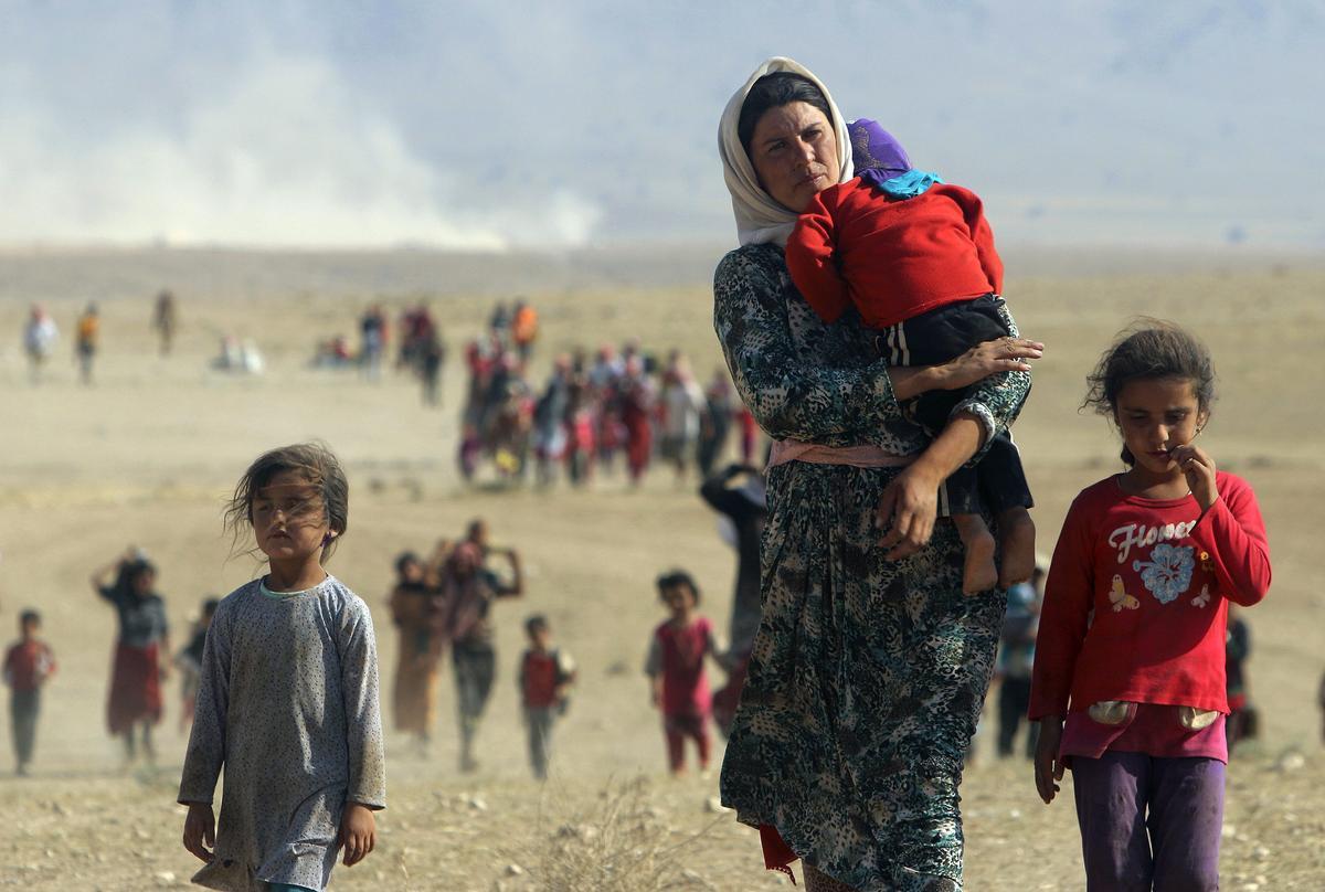 Una mujer yazidí con dos niñas huye del Estado Islámico. 