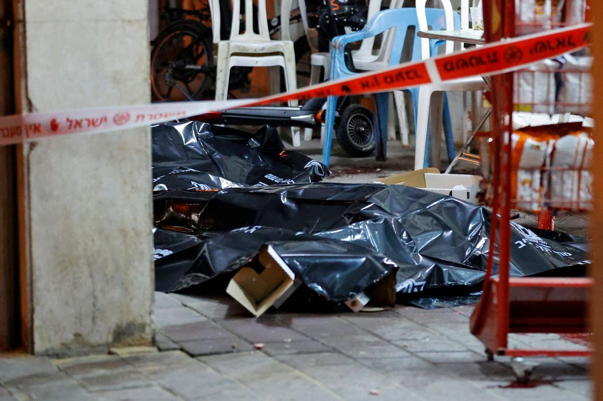 Los cuerpos de algunas de las víctimas del atentado en la ciudad de Bnei Brak, próxima a Tel Aviv, yacen en el suelo cubiertos con plásticos.