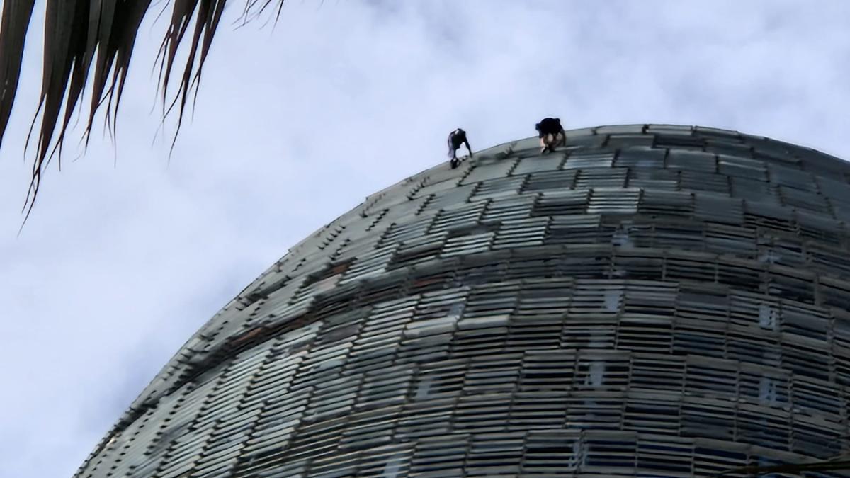 Dos hombres escalan la Torre Glòries de Barcelona, este sábado 1 de octubre de 2022. 