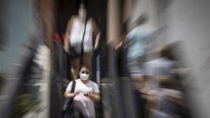Una persona baja las escaleras del Hospital Vall d’Hebrón cubierta con una mascarilla sanitaria.