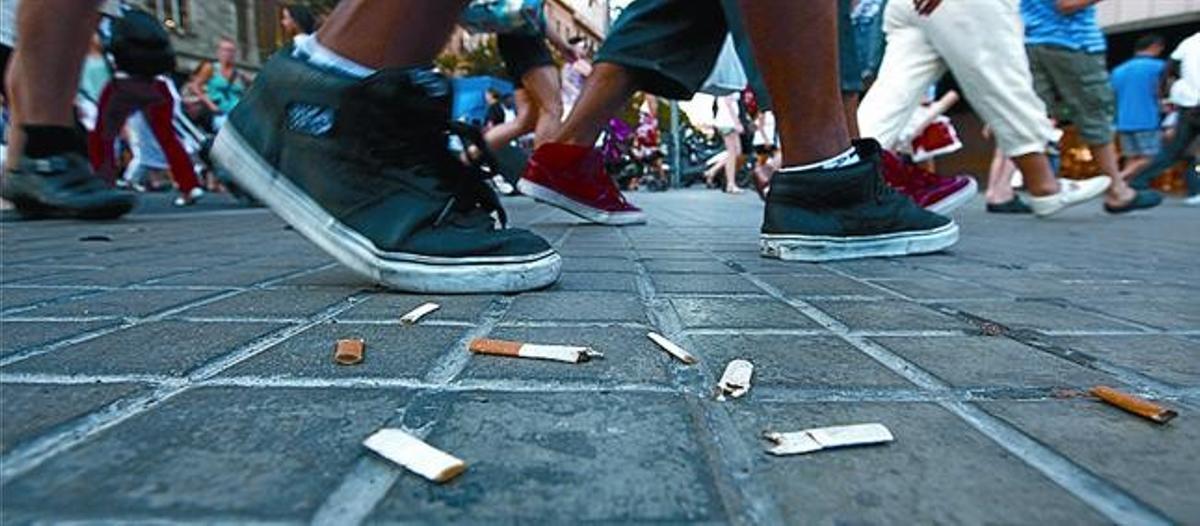 Colillas de tabaco al paso de jóvenes.