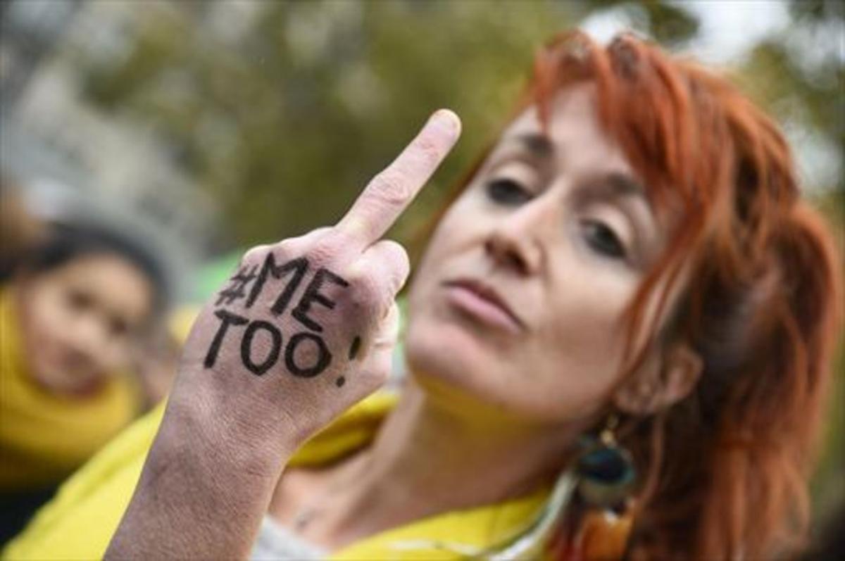 Una mujer conel lema #MeToo escrito en la mano gesticula en París.