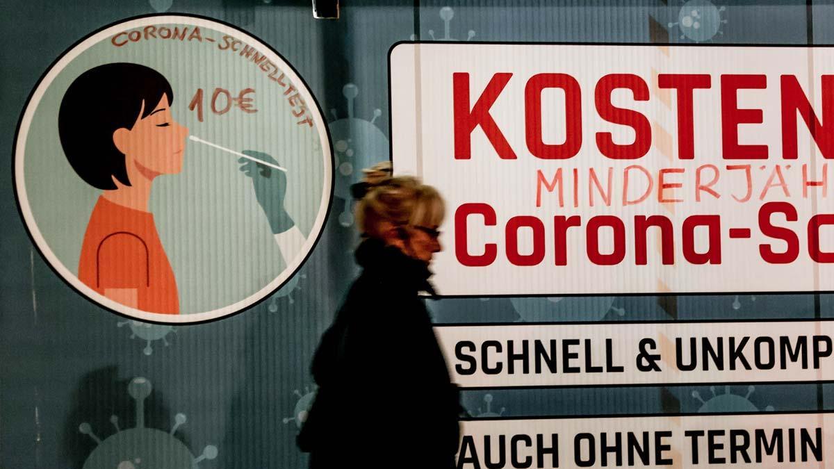 Los contagios por covid en Alemania se disparan a un nuevo máximo de 50.000 en un día. En la foto, una mujer pasa frente a un centro de realización de tests de coronavirus en Berlín.