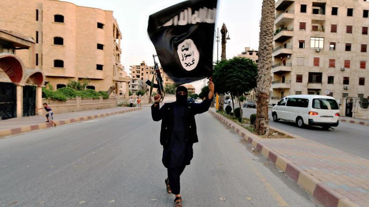 Miembro de Estado Islámico con una bandera durante un desfile militar en la ciudad siria de Raqqa en 2014. Miembro de Estado Islámico con una bandera durante un desfile militar en la ciudad siria de Raqqa en 2014.