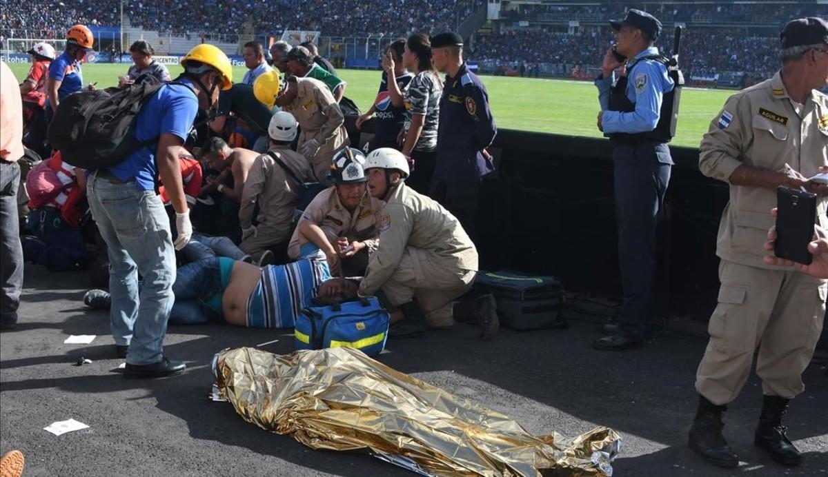 Las asistencias médicas atienden a varios heridos cerca de uno de los dos fallecidos dentro del estadio.
