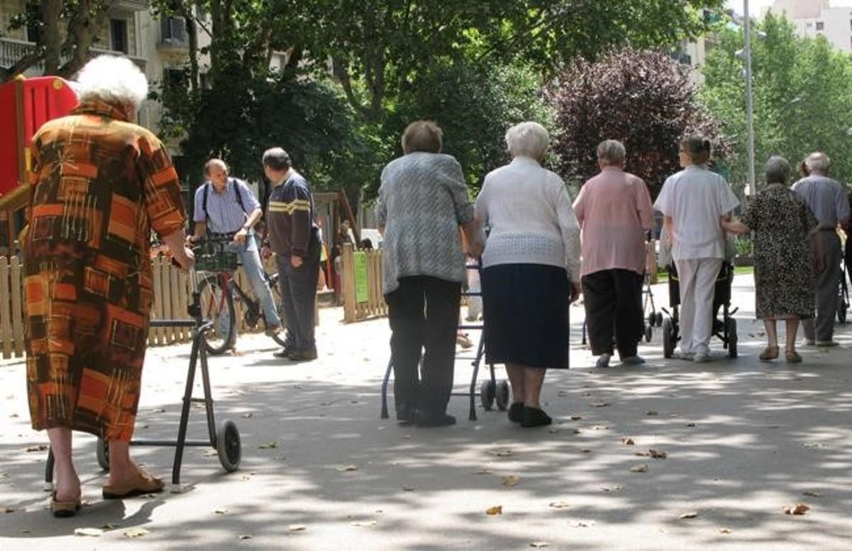 Un grupo de jubilados caminan por el paseo de Sant Joan, en Barcelona.