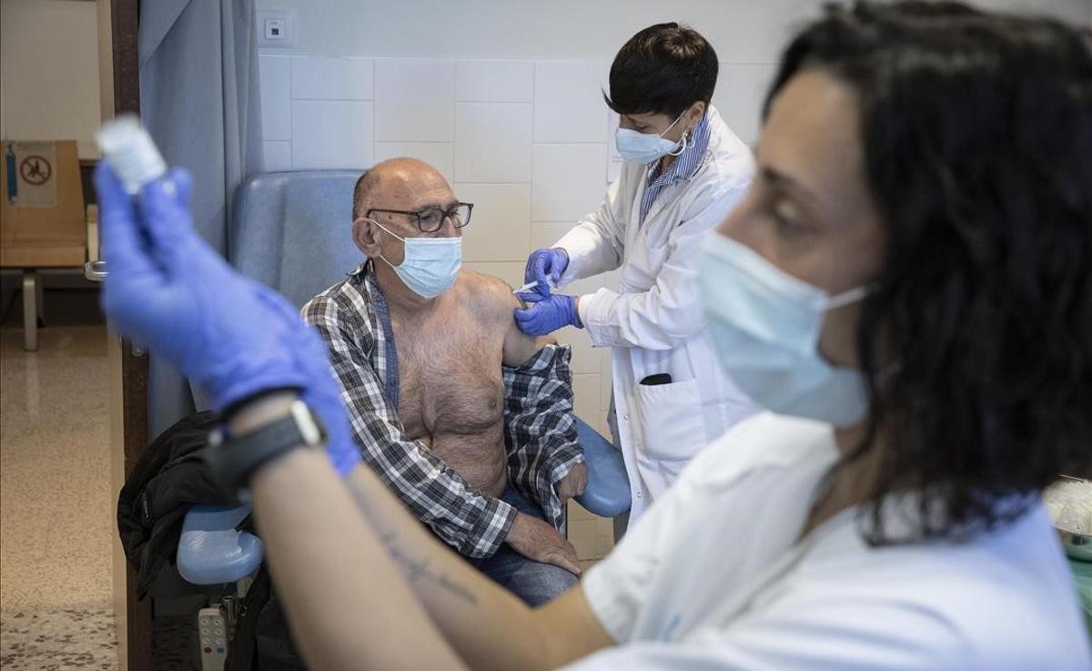 Un hombre mayor recibe la vacuna en el CAP Casernes, en Barcelona.