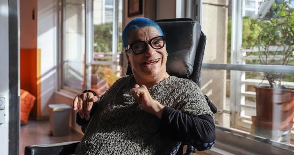 Feliz y con una sonrisa en su rostro posa en el salón de su casa To Monreal, una mujer con parálisis cerebral Feliz y con una sonrisa en su rostro posa en el salón de su casa To Monreal, una mujer con parálisis cerebral