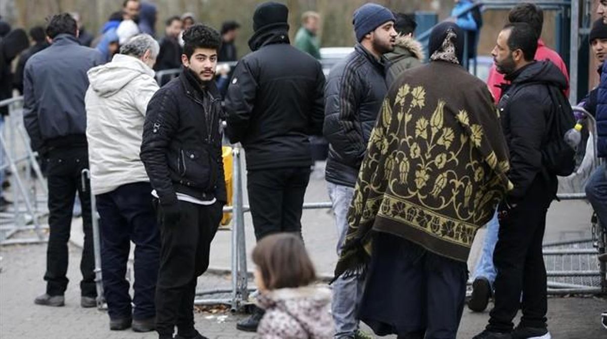 Migrantes esperan para registrarse frente a la oficina federal de migración y refugiados del distrito de Spandau, en Berlín (Alemania). Migrantes esperan para registrarse frente a la oficina federal de migración y refugiados del distrito de Spandau, en Berlín (Alemania).