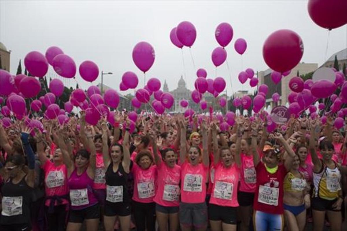 Participantes en la carrera solidaria por el cáncer de mama sujetan globos rosas, en una imagen de archivo.