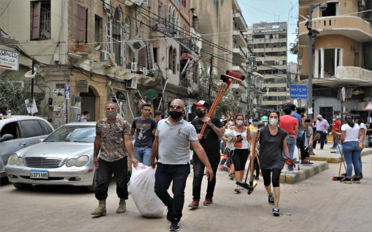 Voluntarios limpian las calles y las edificaciones destrozadas por la explosión Beirut.