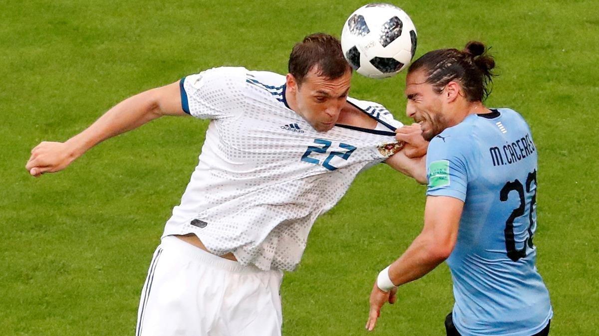 Martín Cáceres, de celeste, pugna con Artem Dzyuba en el Uruguay-Rusia del Mundial-2018.