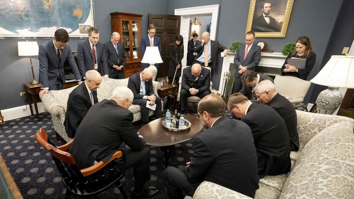 Mike Pence (sentado en una silla en primer plano, de espaldas) reza junto a su equipo de trabajo en la Casa Blanca, el pasado día 26.