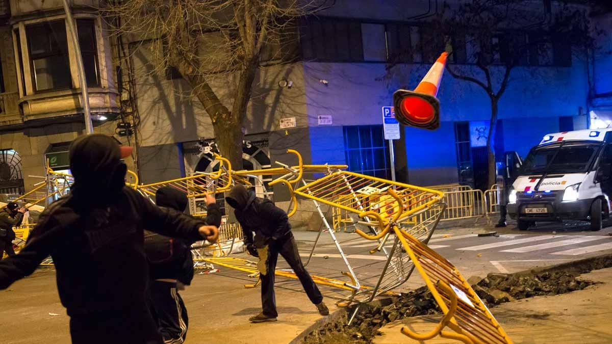 Manifestantes en apoyo a Pablo Hasel tiran vallas y conos contra los Mossos, durante una protesta en Girona. Manifestantes en apoyo a Pablo Hasel tiran vallas y conos contra los Mossos, durante una protesta en Girona.