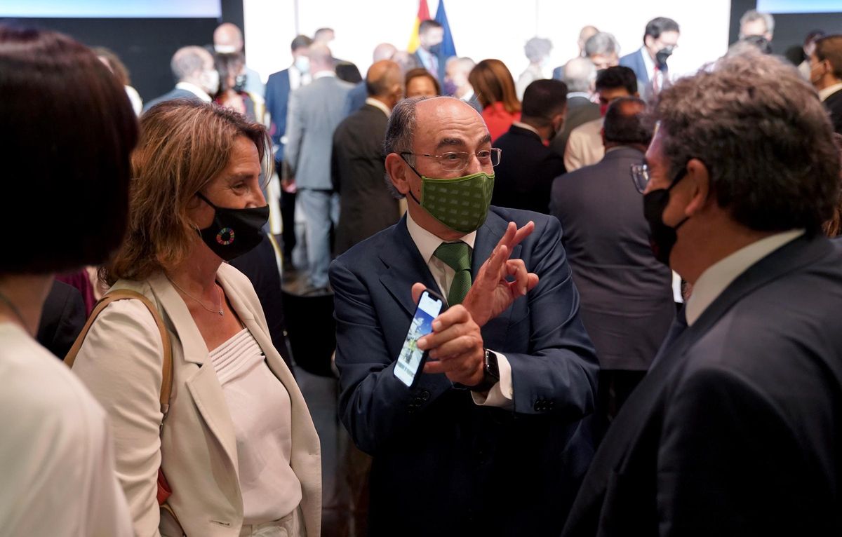 El presidente de Iberdrola, Ignacio Sánchez Galán, muestra su móvil a la vicepresidenta tercera y ministra de Transición Ecológica, Teresa Ribera, mientras conversa con el ministro de Seguridad Social, José Luis Escrivá. El presidente de Iberdrola, Ignacio Sánchez Galán, muestra su móvil a la vicepresidenta tercera y ministra de Transición Ecológica, Teresa Ribera, mientras conversa con el ministro de Seguridad Social, José Luis Escrivá.