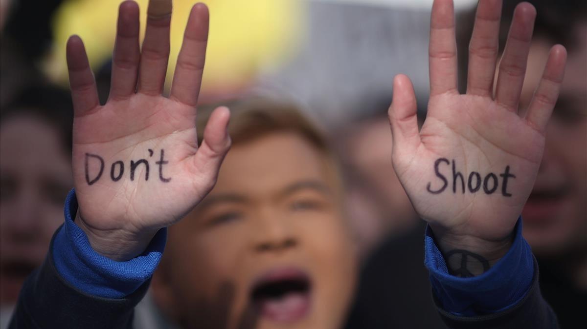 Un joven manifestante en Washington con las palabras No Dispares escritas en las palmas de sus manos.