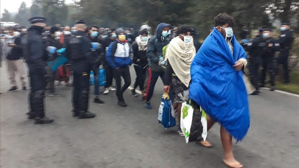 La policía francesa conduce este martes a un grupo de migrantes en el desalojo del campo de Calais. La policía francesa conduce este martes a un grupo de migrantes en el desalojo del campo de Calais.