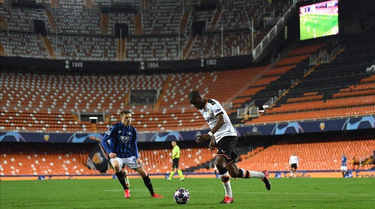 Ilicic y Kondogbia disputan un balón en el Valencia-Atalanta disputado a puerta cerrada. 