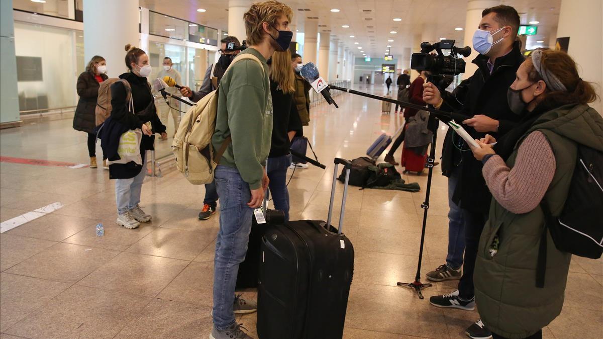 Pasajeros procedentes de Londres atienden a los periodistas a su llegada, este martes, al aeropuerto del Prat.
