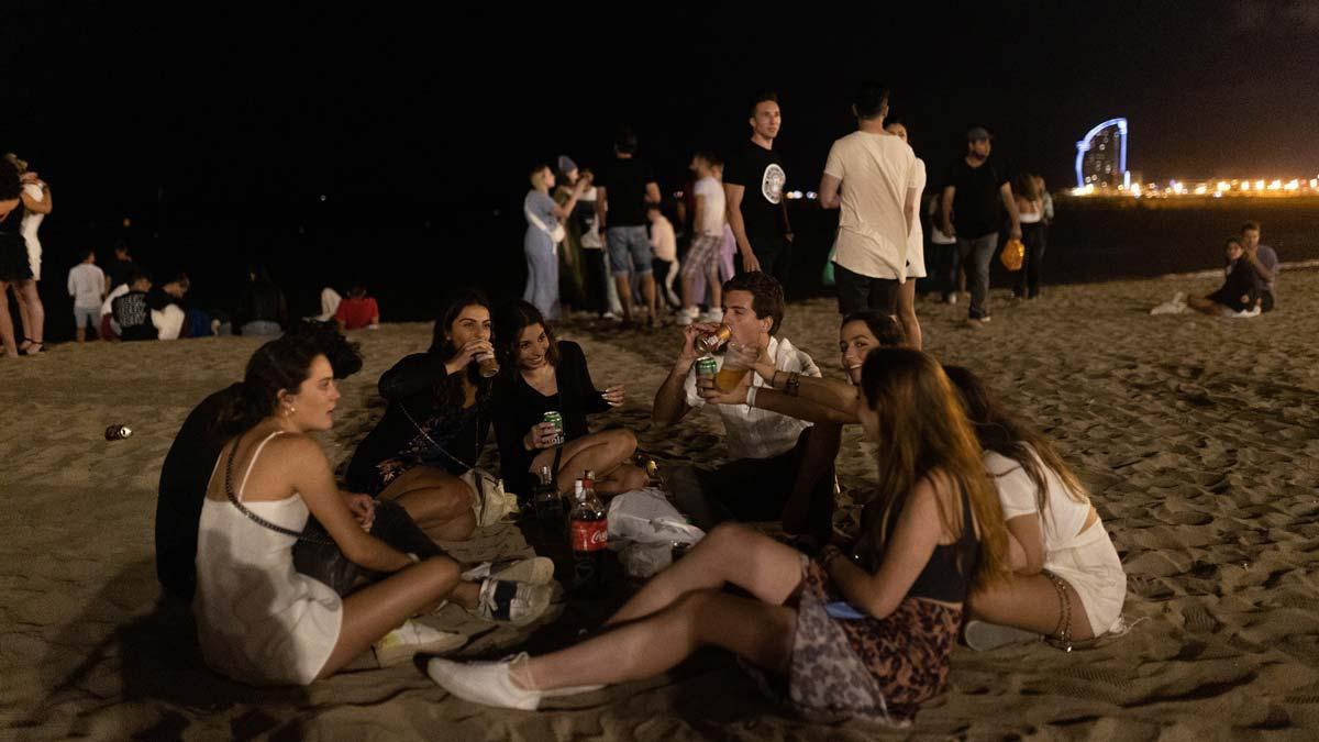 Un grupo hace botellón en la playa del Somorrostro, tras el cierre de los establecimientos de ocio nocturno en Barcelona.