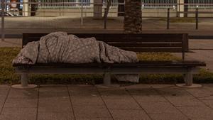 Una persona sin hogar duerme en la calle en Barcelona