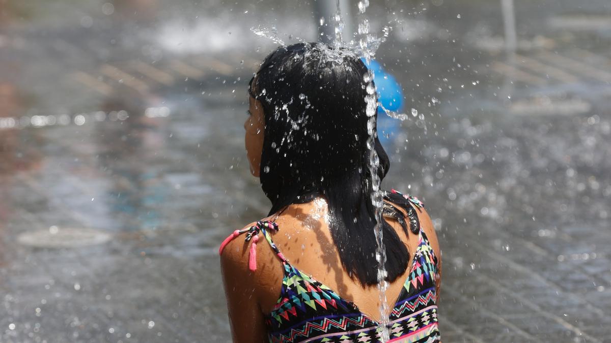 Una niña se refresca en una fuente en Madrid, este lunes.
