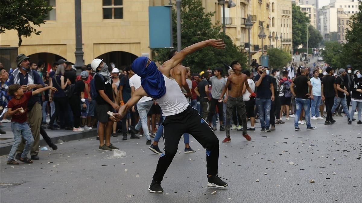 Un manifestante lanza una piedra contra la policía durante las protestas en Beirut, este martes. Un manifestante lanza una piedra contra la policía durante las protestas en Beirut, este martes.