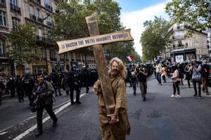 Un manifestante carga con una cruz con el mensaje La vacuna mata tu inmunidad natural , este sábado en la protesta de París.