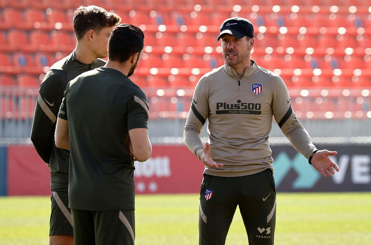 El técnico del Atlético Diego Simeone charla con sus jugadores durante un entrenamiento.