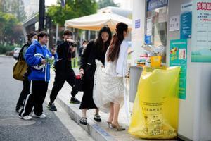 Una novia va a hacerse un test de covid vestida con el traje de boda, este martes en la ciudad china de Shanghái.