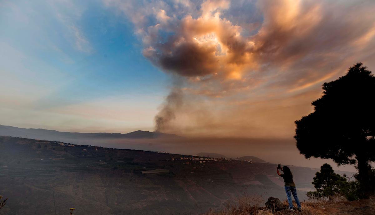 Una mujer toma una fotografía de la erupción volcánica en La Palma, cerca del Valle de Aridane.
