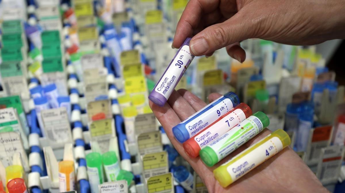 Un homeópata muestra varias diluciones supuestamente medicinales, en una farmacia de Niza.
