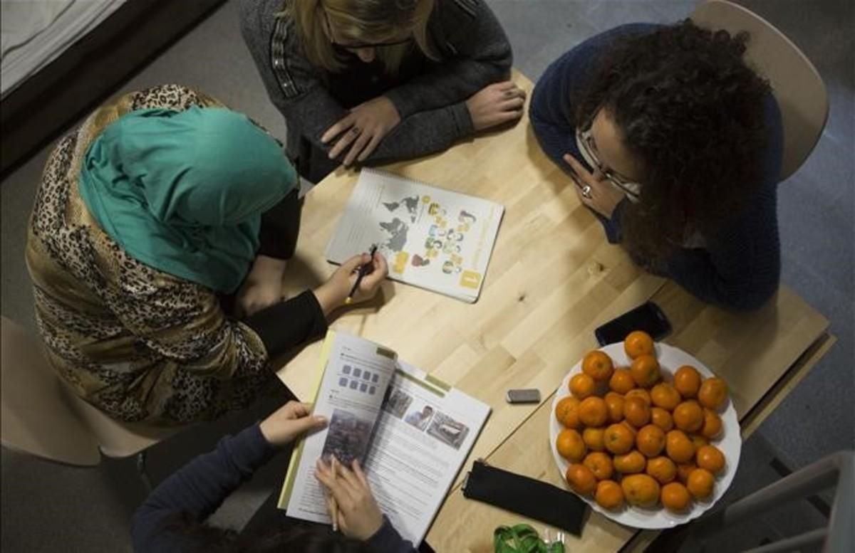 Dos técnicas de Creu Roja imparten una clase de catalán en la Casa Bloc de Barcelona a dos refugiadas. Dos técnicas de Creu Roja imparten una clase de catalán en la Casa Bloc de Barcelona a dos refugiadas.