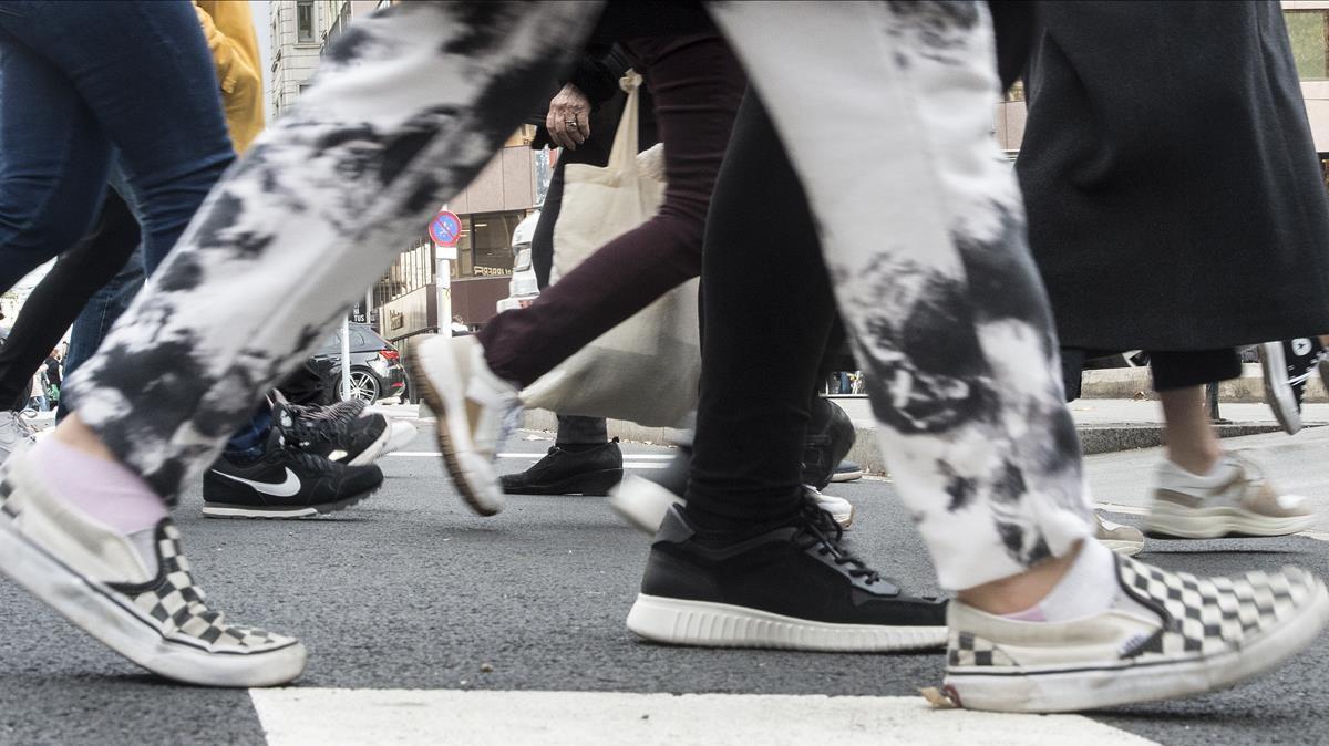 Barcelona     07 12 2020      Sociedad   Aumenta el uso de las zapatillas deportivas como calzado diario  En la foto    desfile de  sneakers   cruzando la calle Aragon   Fotografia de Jordi Cotrina