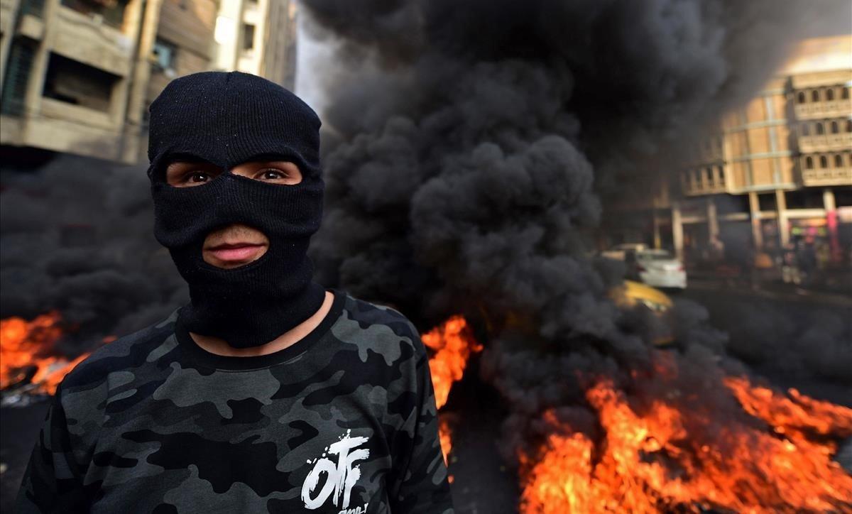 Un manifestante quema neumáticos durante una protesta contra la corrupción y para reclamar más servicios básicos, en la plaza de Wathba, en Bagdad, el 1 de diciembre.