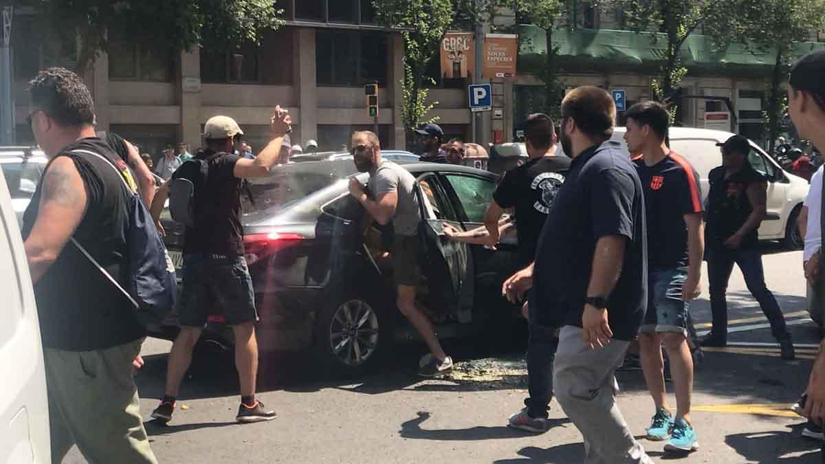 Manifestantes violentos atacan un coche de Cabify durante la huelga de taxis en Barcelona.