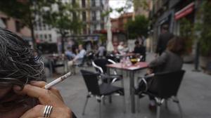 Una persona fuma en la terraza de un bar de Madrid, que está en la fase 1 de la desescalada.