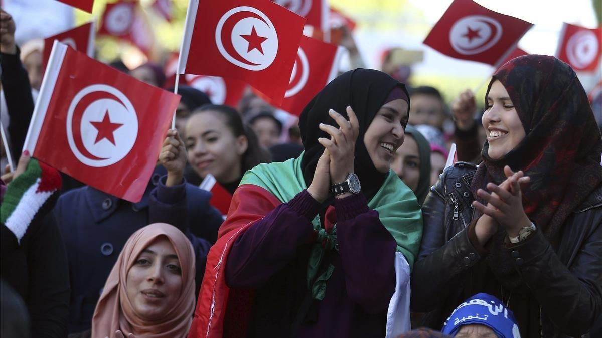 Varias mujeres ondean banderas nacionales durante la celebración del quinto aniversario de la caída de la dictadura de Ben Alí en la avenida Habib Bourguiba, en Túnez. Varias mujeres ondean banderas nacionales durante la celebración del quinto aniversario de la caída de la dictadura de Ben Alí en la avenida Habib Bourguiba, en Túnez.